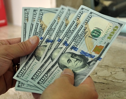 Dólar segue exterior, recua e termina abaixo de R$3,70