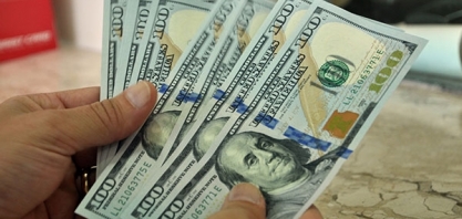 Dólar segue exterior, recua e termina abaixo de R$3,70