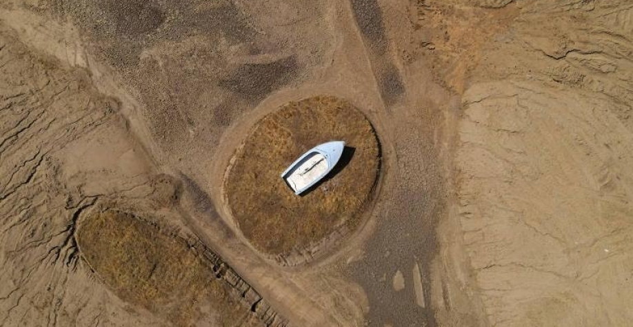 Legenda: Barco fica encalhado onde antes era o lago Hensley, em Madera, na Califórnia (EUA), região em que a seca continua a castigar e a diminuir os reservatórios de água - David Swanson/Reuters