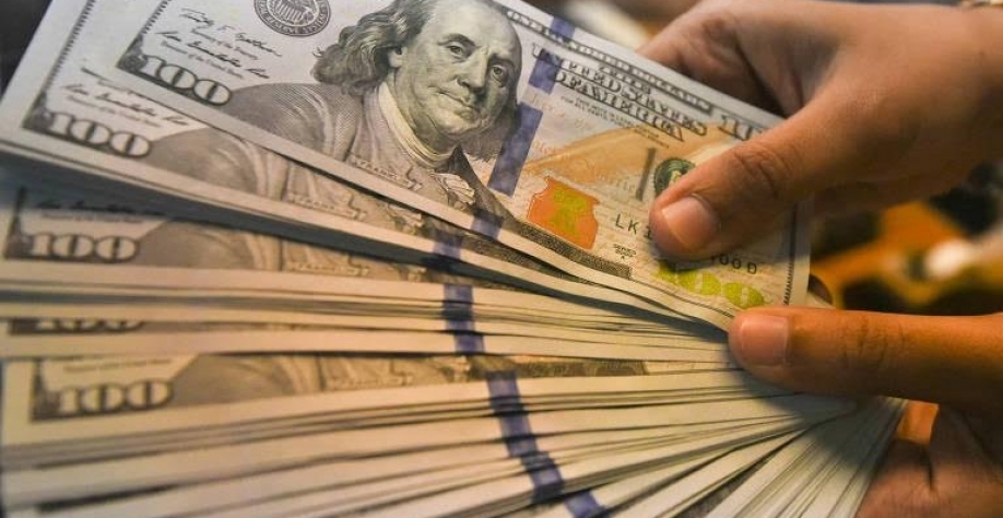 Legenda: Notas de dólar manipuladas por funcionário de casa de câmbio em Jacarta, na Indonésia - Hafidz Mubarak/Reuters