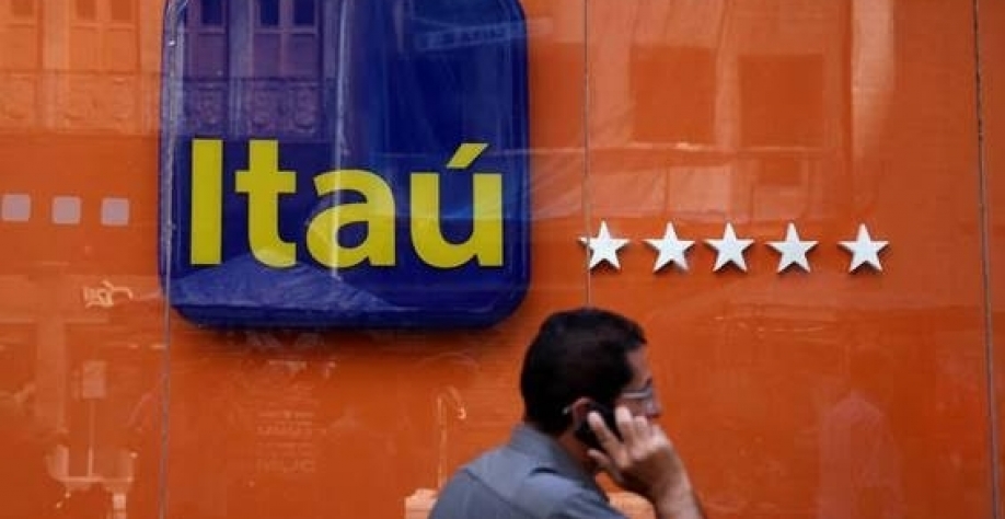 Homem caminha à frente de logo do Itaú Unibanco no Rio de Janeiro, Brasil (Foto: Pilar Olivares/Reuters)