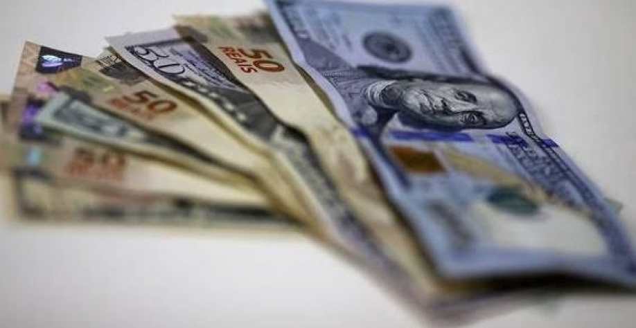 Notas de dólar e de real Envio de recursos para o exterior parece medida incoerente de proteção - foto -Ricardo Moraes-Reuters